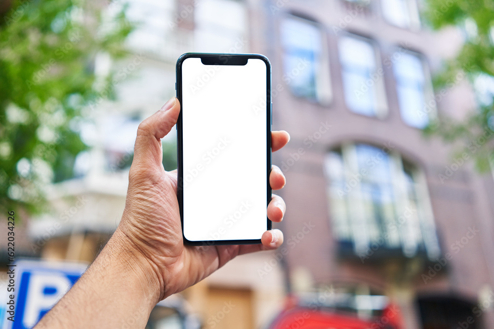 Man holding smartphone showing white blank screen at street Man holding smartphone showing white blank screen at street