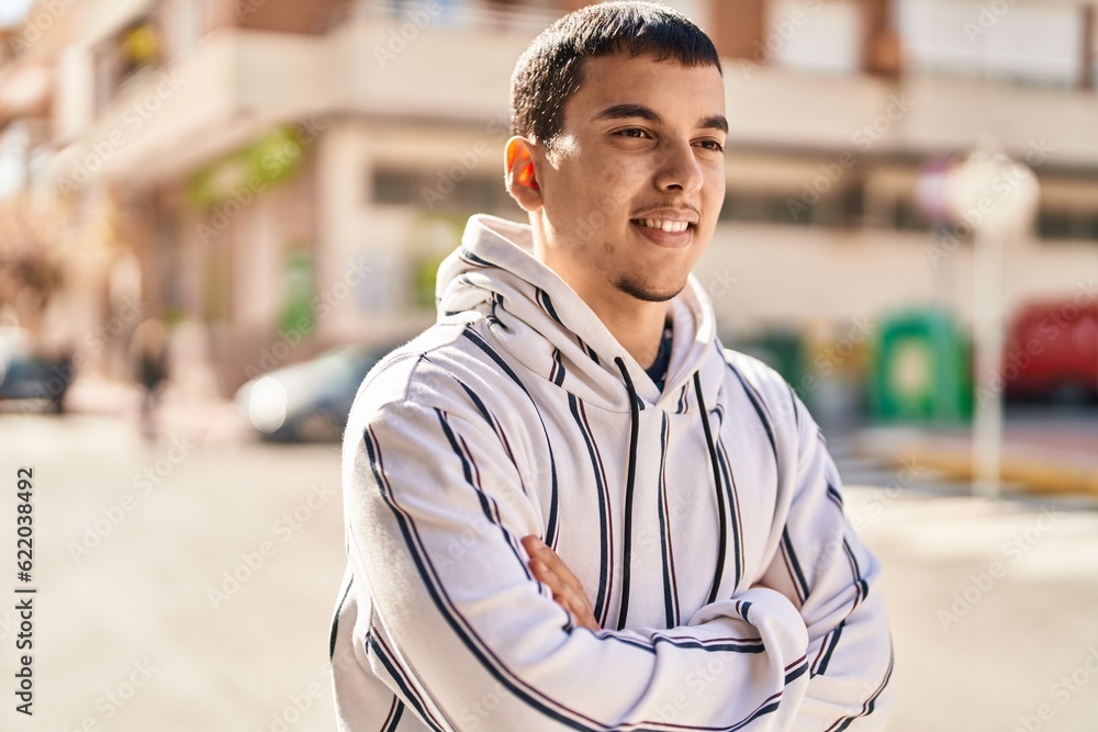 Young man smiling confident standing with arms crossed gesture at street