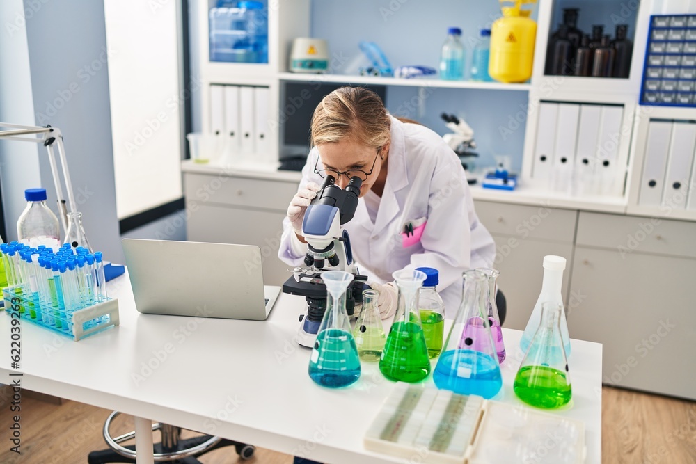 Young blonde woman scientist using microscope at laboratory Young blonde woman scientist using microscope at laboratory