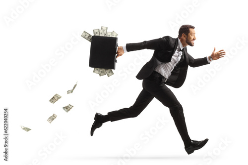 Full length profile shot of a businessman running fast and carrying a briefcase with money