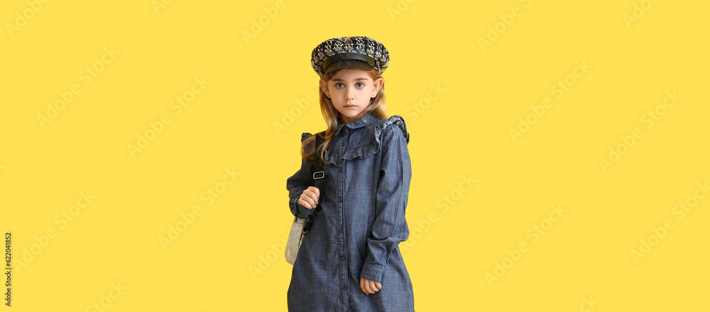 Cute little girl in stylish autumn clothes on yellow background Cute little girl in stylish autumn clothes on yellow background