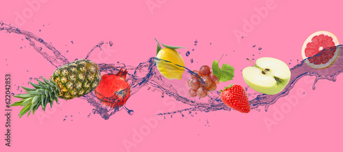 Fresh fruits and water splash on pink background