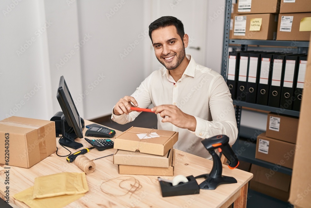 Young hispanic man e-commerce business worker make photo to package at office Young hispanic man e-commerce business worker make photo to package at office