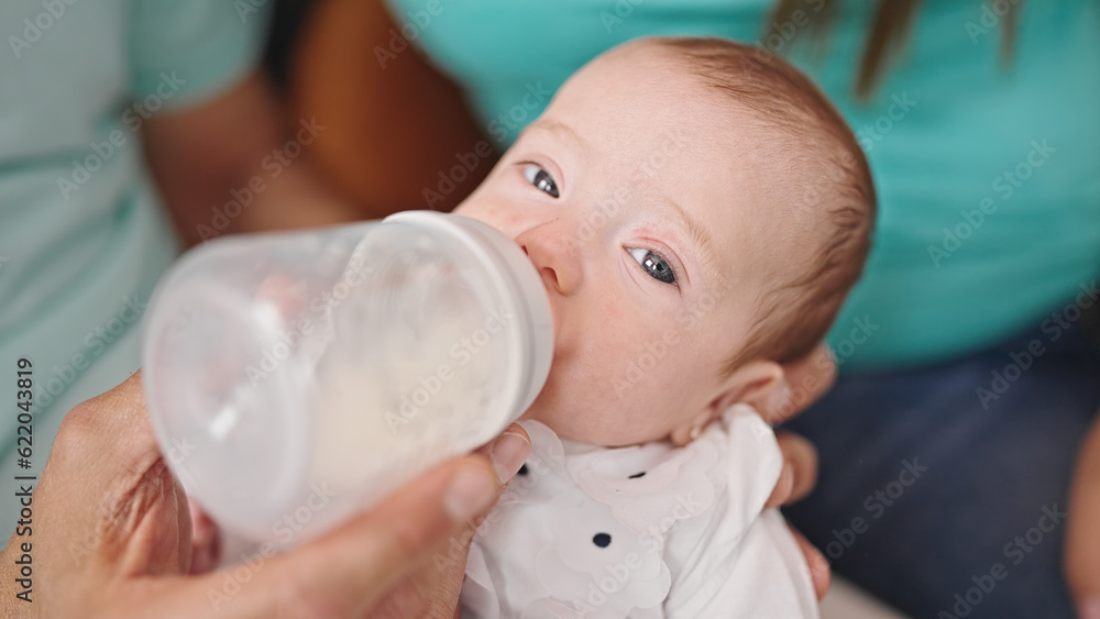 Caucasian baby girl drinking milk from feeding bottle Caucasian baby girl drinking milk from feeding bottle