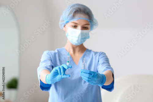 Nurse with ampule and syringe in clinic