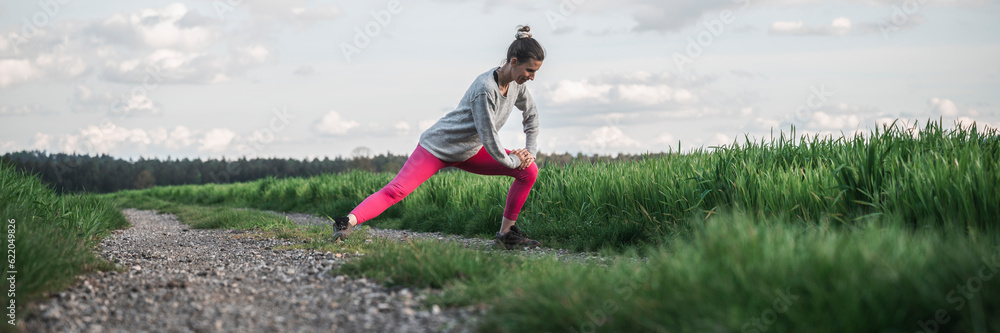 Young woman in pink leggings stretching before going for a run