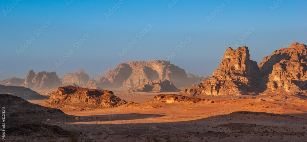 Magic mountain landscapes of Wadi Rum Desert, Jordan. Mountains in lifeless desert resemble Martian craters.  Sand is beautiful pink color and and red rocks. There is place for text.
