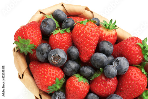 Wicker basket with ripe strawberry and blueberry on white background  closeup