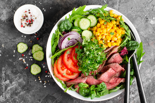 Beef steak and Fresh Vegetables Buddha Bowl, Healthy Balanced Meal on Dark Background © julie208