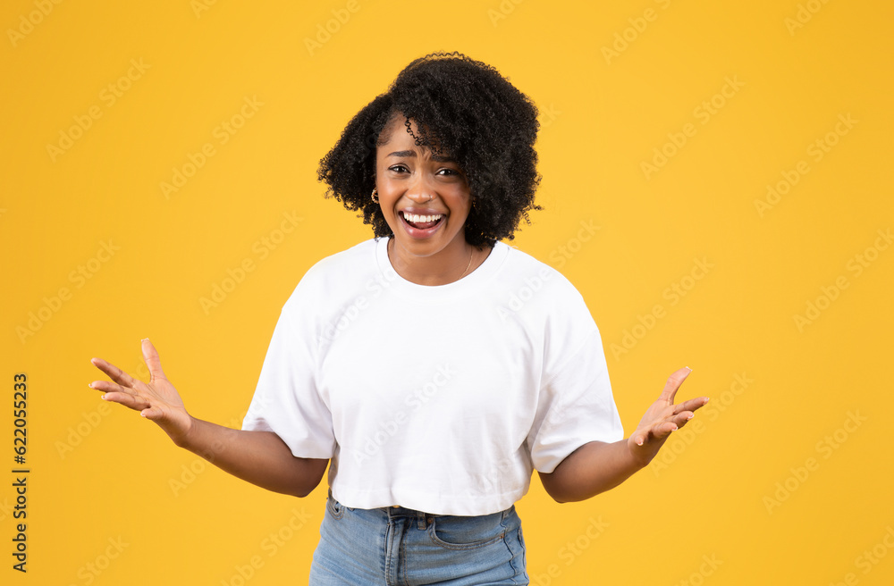 Happy laughing surprised millennial black lady in casual spread arms to side, rejoices to victory Happy laughing surprised millennial black lady in casual spread arms to side, rejoices to victory