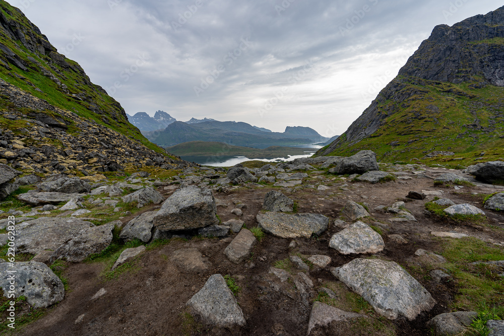 passage d'un col avec des rochers en premier plan et un lac en arrière plan