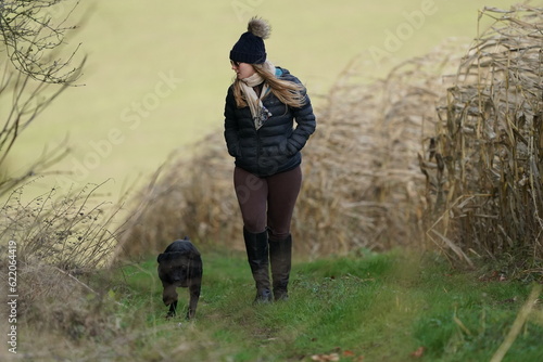 Country girl strolling along with faithful hound