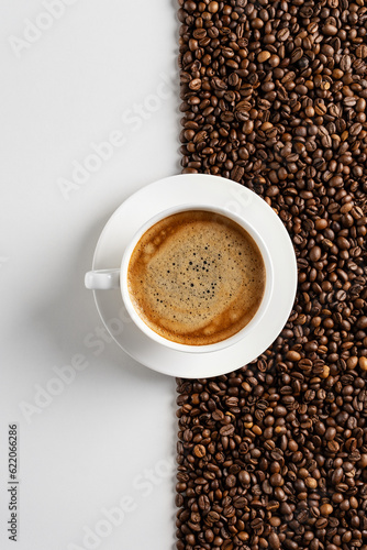 Fototapeta Naklejka Na Ścianę i Meble -  Coffee beans background and a cup of coffee. Contrast. White space on the background with coffee beans