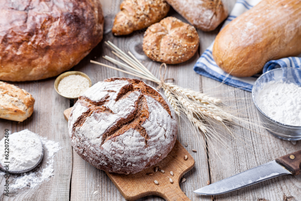 Naklejka premium Delicious freshly baked bread on wooden background