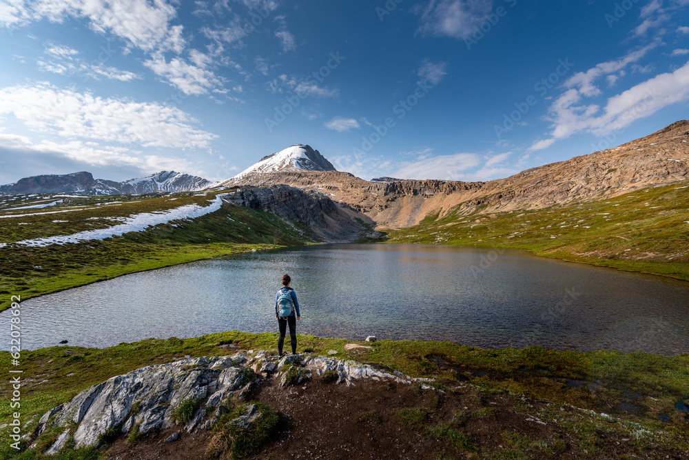Backpacker Girl admires beautiful Helen Lake and Cirque Peak Banff National Park Alberta