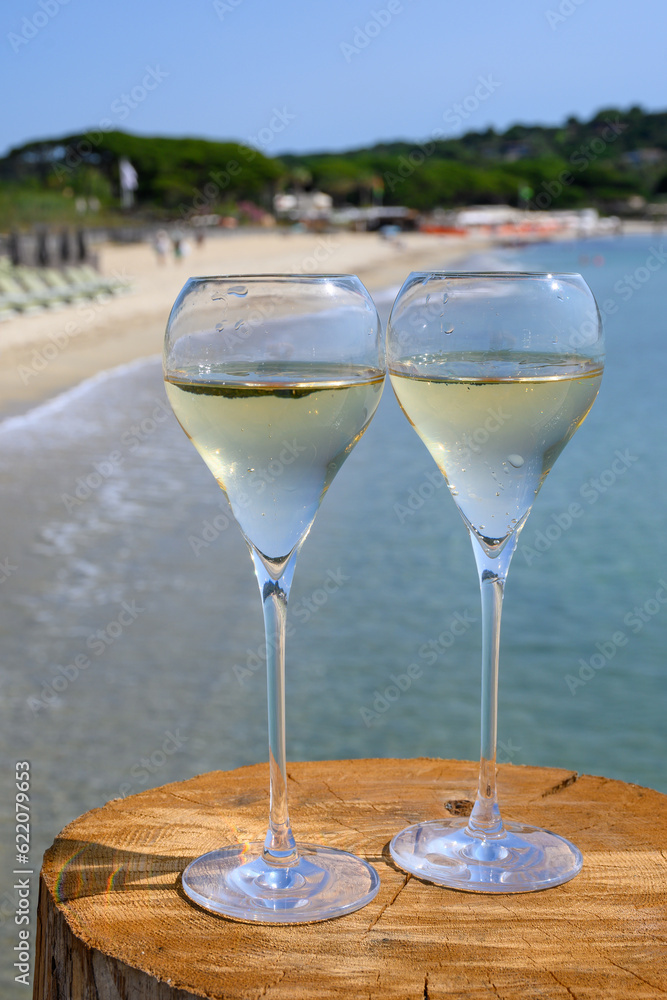 Summer time in Provence, two glasses of cold champagne cremant sparkling wine on famous Pampelonne sandy beach near Saint-Tropez in sunny day, Var department, France Summer time in Provence, two glasses of cold champagne cremant sparkling wine on famous Pampelonne sandy beach near Saint-Tropez in sunny day, Var department, France
