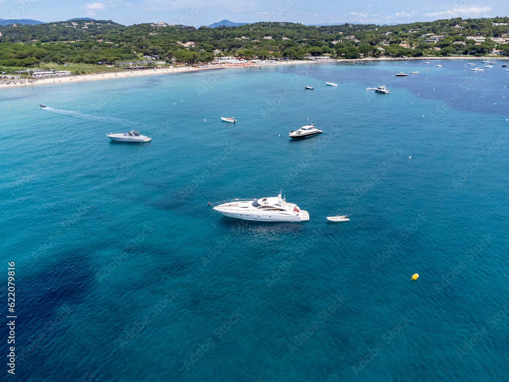 Aerial view on boats, crystal clear blue water of legendary Pampelonne beach near Saint-Tropez, summer vacation on white sandy beach of French Riviera, France Aerial view on boats, crystal clear blue water of legendary Pampelonne beach near Saint-Tropez, summer vacation on white sandy beach of French Riviera, France
