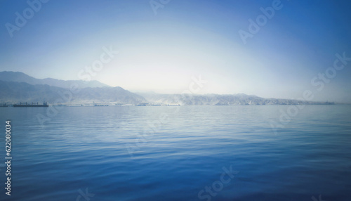 Blurred photo far shore the port and the ships in the distance. Blue filter. Seascape for background