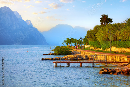 Old town Malcesine on Garda lake. Veneto region. Italy. Picturesque view from embankment track. Sunny summer day and blue high mountains on background photo