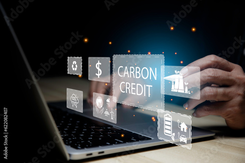 Businessman using laptop analyzing data Carbon Credit Market ,Net zero in 2050 year for ESG eco concept environmental, social, sustainable, ethical. eco green energy system icon around it..