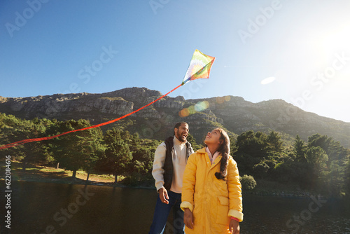 Fotografie Father and daughter watching kite flying during family camping trip with mountai