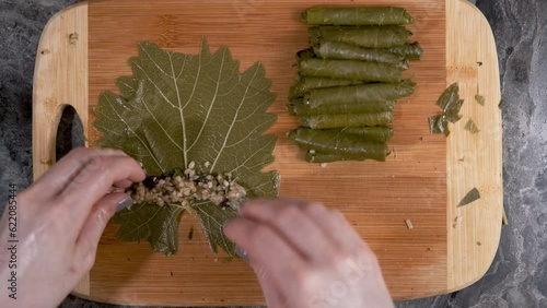 Woman Making Turkish Traditional Food Yaprak Sarma. It Means Stuffed Grape Leaves with Rice. Also Known As Dolma. Close Up Shot of Lady's Hands. Real Time 4K.