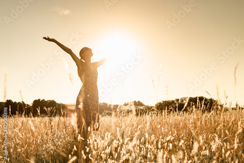 Fotografija Joyful Person Raising Arms morning  in Rural Field Under Summer Sunlight