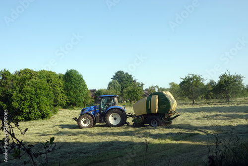 Landwirt bei der Heuernte mit einer Rundballenpresse