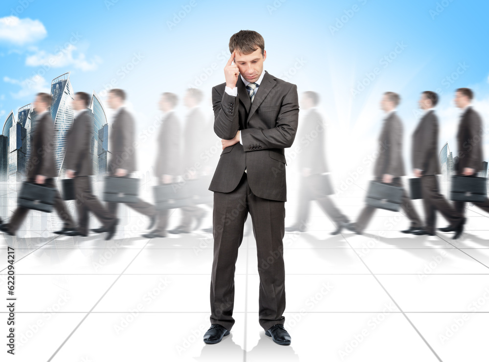 Thinking businessman looking down. Many people walking on background Thinking businessman looking down. Many people walking on background
