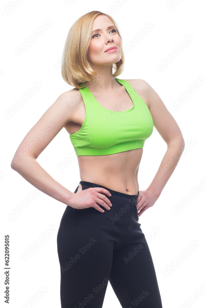 Beautiful middle aged blond fit woman in green bra top and black pants doing sport exercise. Isolated over white background. Copy space. Beautiful middle aged blond fit woman in green bra top and black pants doing sport exercise. Isolated over white background. Copy space.