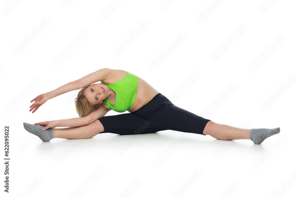 Beautiful middle aged blond fit woman in green bra top and black pants doing sport exercise. Isolated over white background. Copy space. Beautiful middle aged blond fit woman in green bra top and black pants doing sport exercise. Isolated over white background. Copy space.