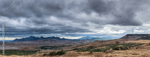 Running storm clouds on a background of mountains. Panorama