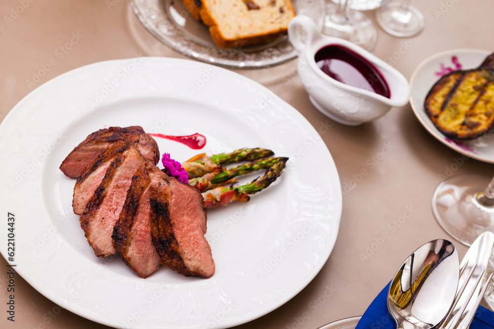 Grilled duck breast with bacon asparagus and raspberry sauce