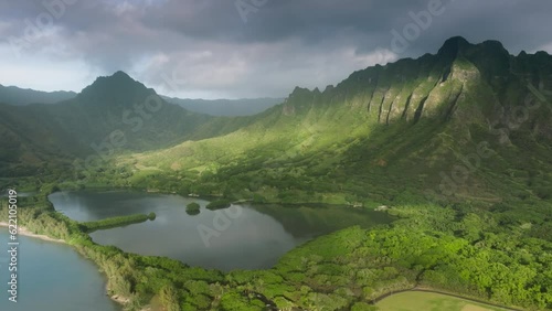 Jurassic world untouched nature on Oahu island, Hawaii. Scenic green mountain ridge outdoor adventure travel background. Cinematic landscape of world famous filming location Kualoa Ranch park sunrise photo