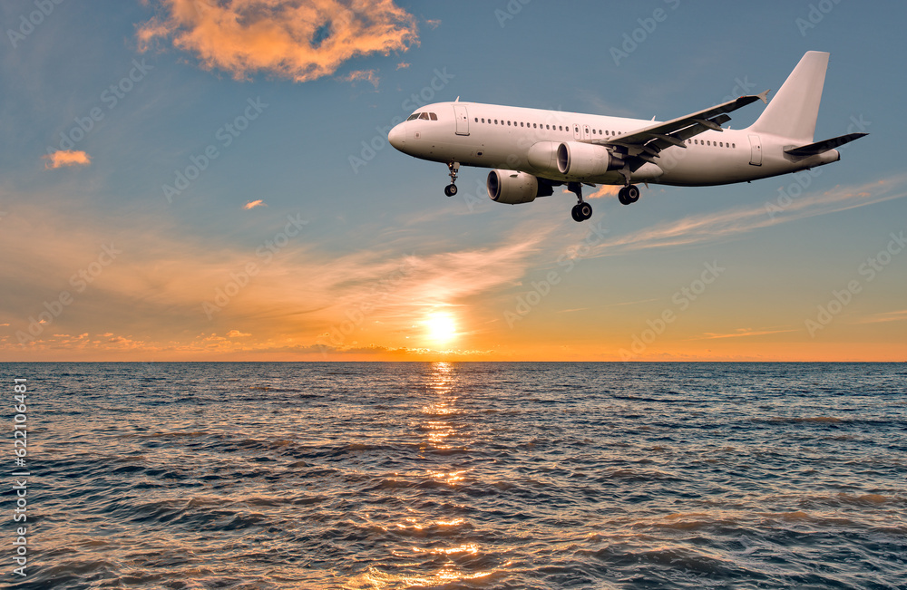 Flight of the plane above the ocean before landing at sunset.