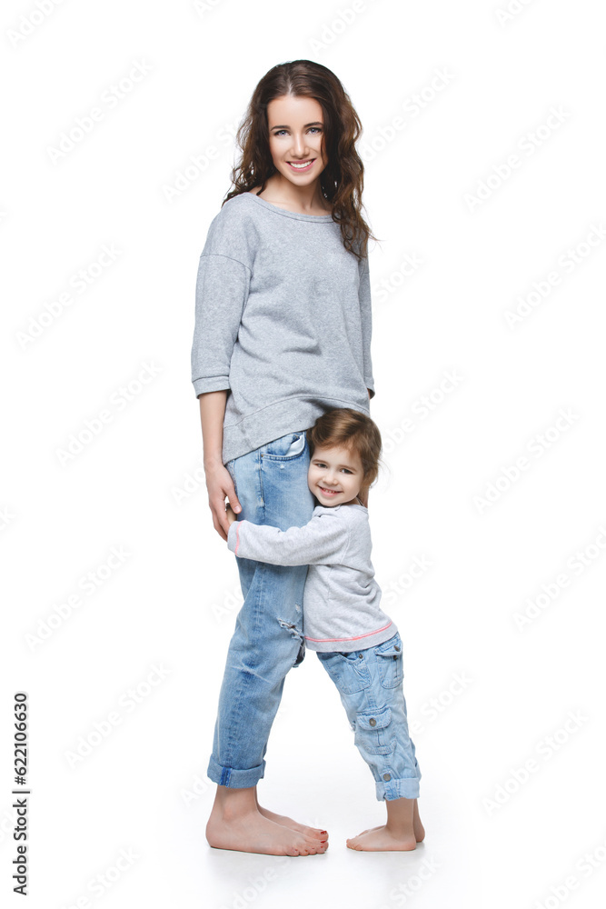 Fototapeta premium Beautiful young woman with little girl. Mother and daughter isolated over white background. Copy space.