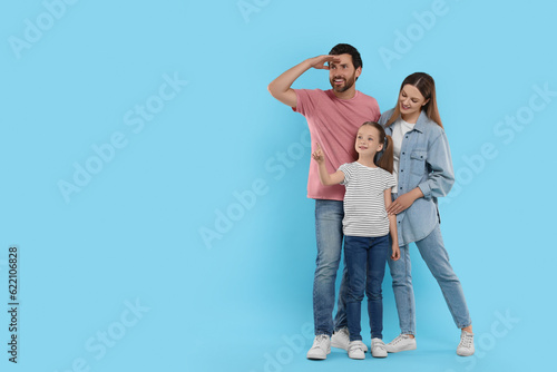 Happy family on light blue background, space for text © New Africa