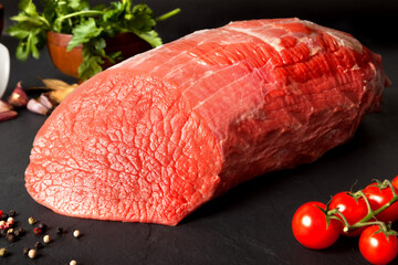 Still life raw beef round over black ground