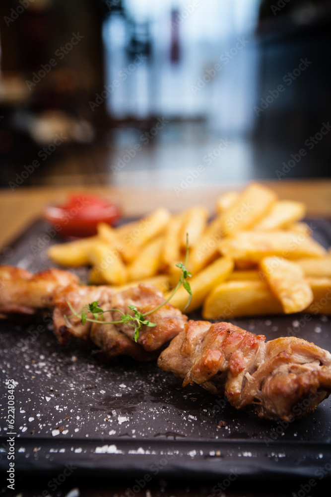 Barbecue grilled pork shashlik kebabs served with french fries