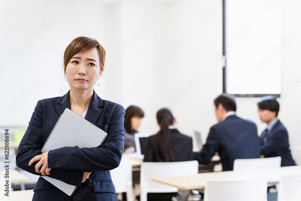 オフィスでノートパソコンを持って考えるビジネスウーマン（IT企業）
