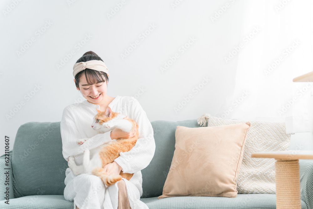 Obraz na plátně 家で猫を抱っこする日本人女性（ペット・飼い主）