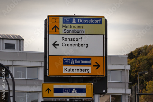 Selective blur on a german roadsign in Wuppertal, Germany, indicating directions to autobahn motorway to Dortmund & Dusseldorf & smaller cities: Mettmann, Sonnborn, Ronsdorf, Cronenberg, Katernberg.