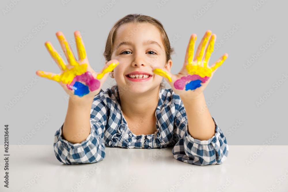 Cute smiling little girl with hands in paint