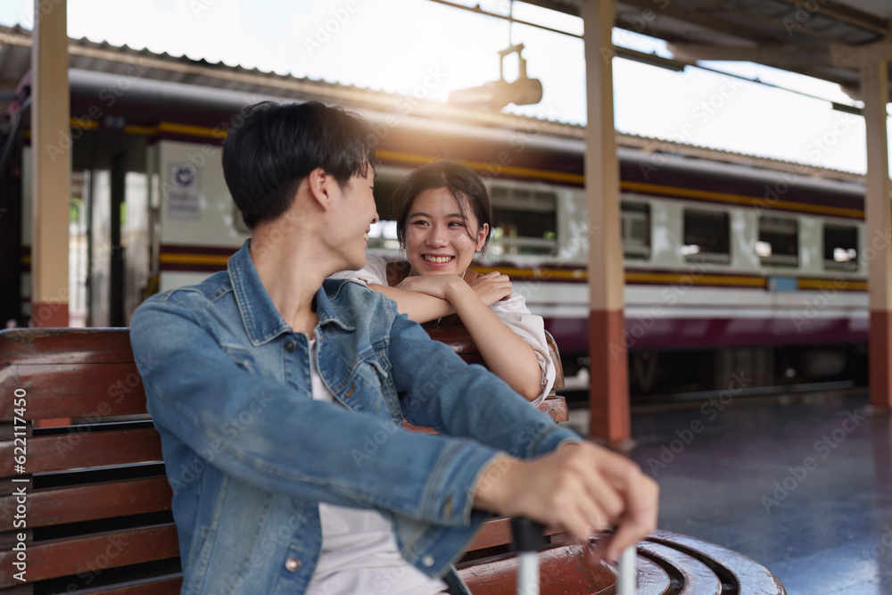 Asian couple at railway station have happy moment. Tourism and travel in the summer