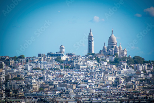 Fotografie The Sacre Coeur Basilica is seen in the distance from on top of the Arc de Triomphe in Paris, France