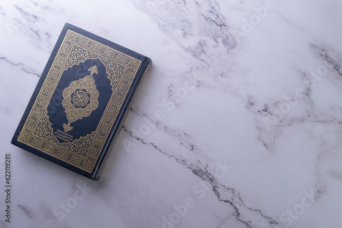 Islamic concept - The Holy Al Quran with written Arabic calligraphy meaning of Al Quran and rosary beads or tasbih, Arabic word translation: The Holy Al Quran (holy book of Muslims)