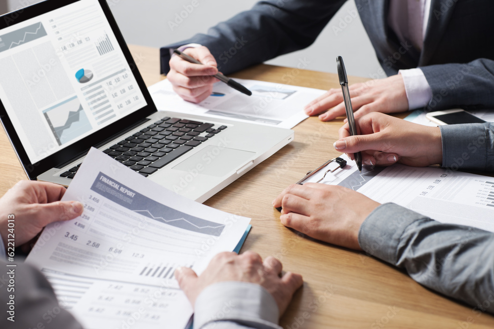 Business professionals working together at office desk, hands close up pointing out financial data on a report, teamwork concept Business professionals working together at office desk, hands close up pointing out financial data on a report, teamwork concept
