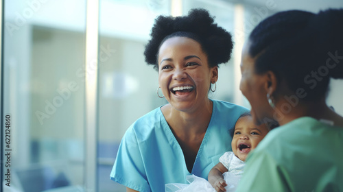 African female nurse holding a baby laughing