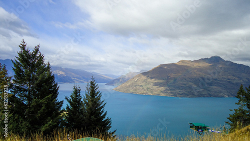 view of the lake with a rainbow from the mountain in queenstown, new zeland.