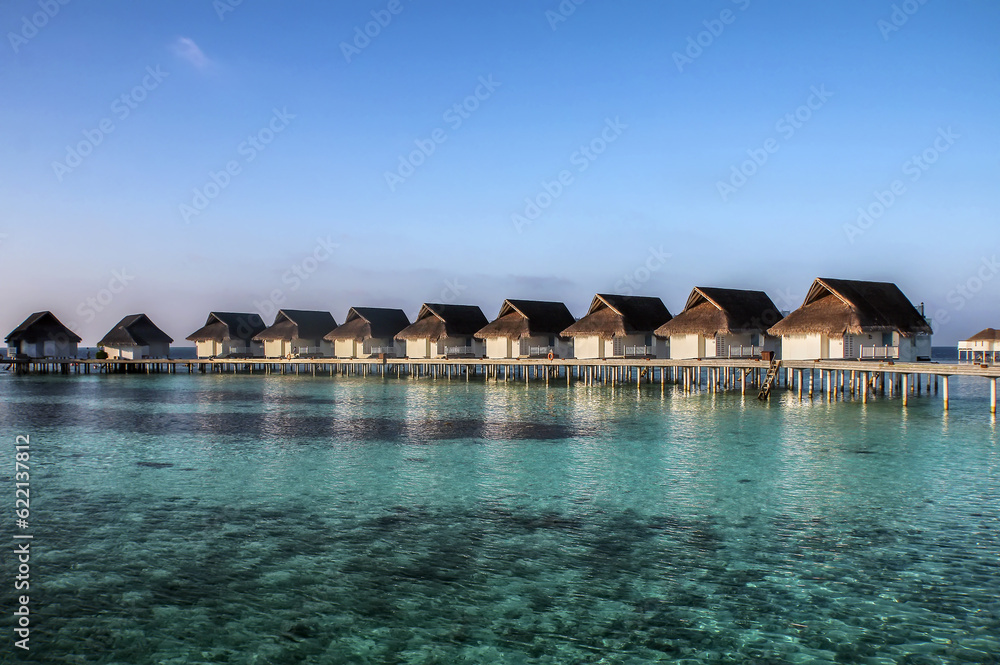 Picturesque bungalows on stilts near the shore of a tropical island, Maldives